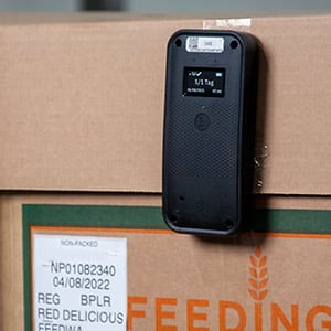 Photo of a crate of apples with a Transparent Path cellular sensor attached and operational.